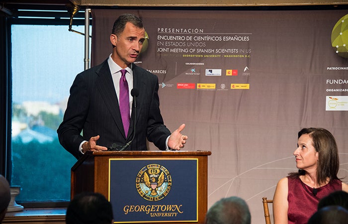 King Felipe VI delivers remarks from a podium in Riggs Library at Georgetown University.