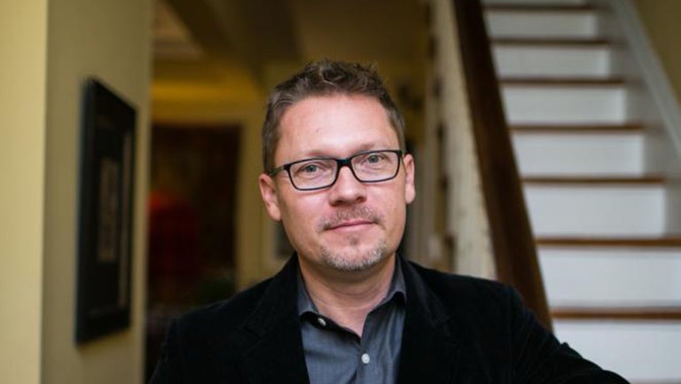 Charles King, in black-framed glasses, smiles in a headshot.