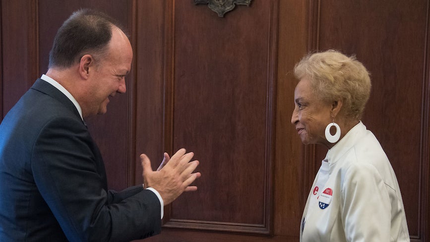 President John J. DeGioia (clapping hands) with GU 272 descendant Onita Estes-Hicks at Georgetown