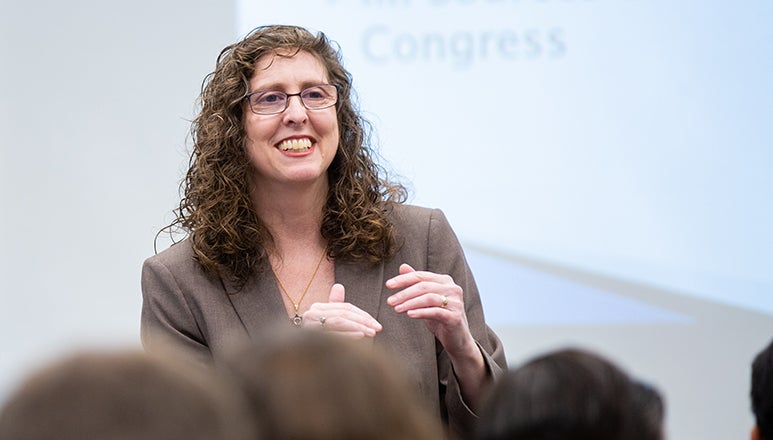 Michele Swers gesturing to students with a screen behind her with the word congress