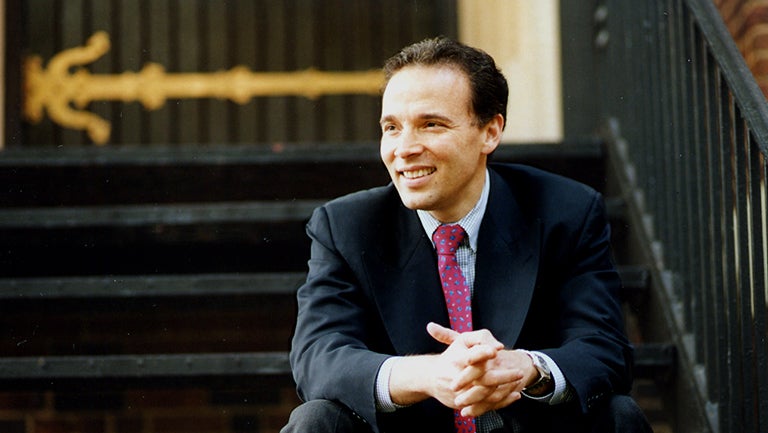 Ricardo Ernst, sitting on steps with hands folded on lap