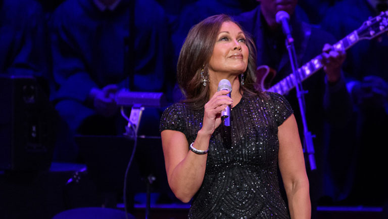 Vanessa Williams sings on stage with choir behind her