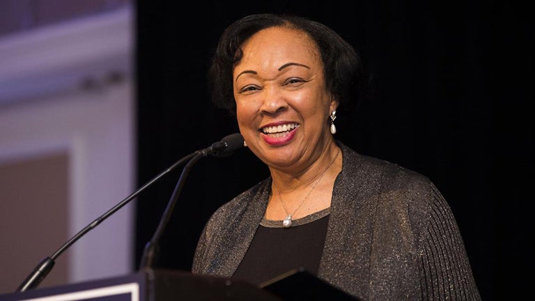 Gwendolyn Mikell smiling at a podium