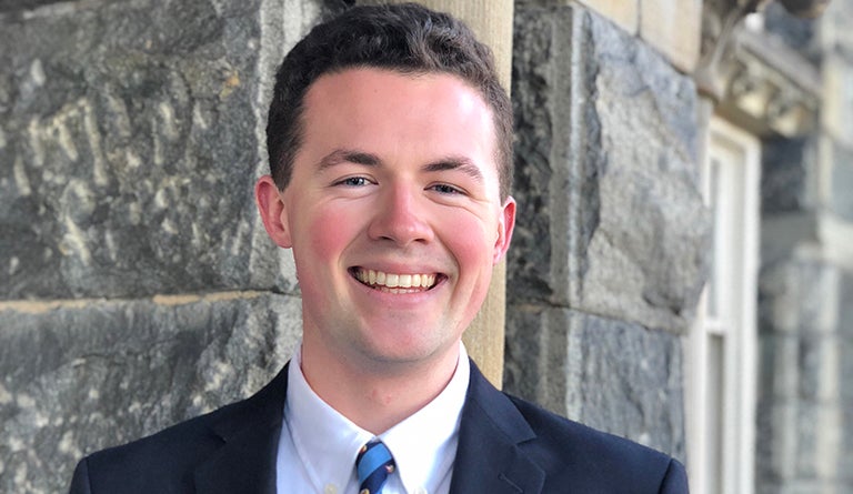 Patrick Mulcahey (C'19) standing against the bricks of the Healy Building