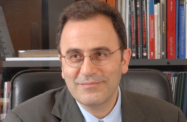 Ahmad Dallal sitting with books behind him