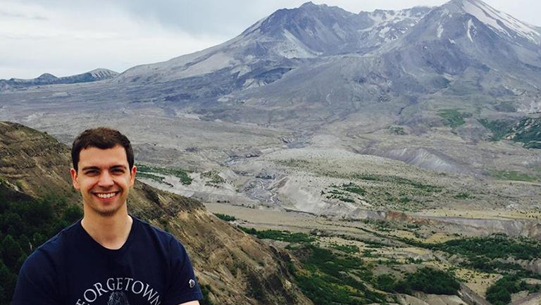 Dagomar Degroot standing in front of Mount St. Helen's volcano