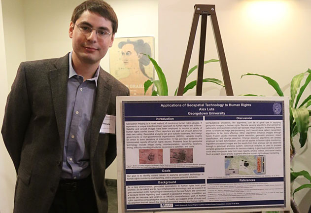 Alex Luta stands next to a research poster