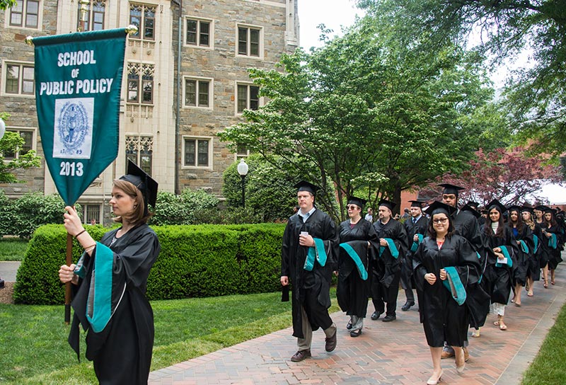 McCourt School grads processional with tree and building in background