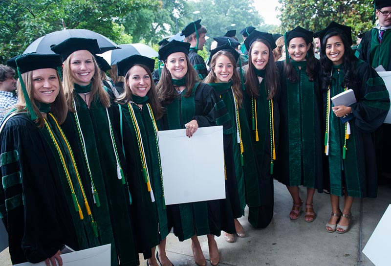 School of Medicine Graduates in cap and gown with diplomas