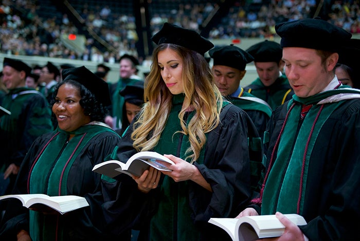 School of Medicine graduate sings with others at commencemcent ceremony