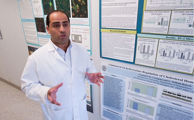 Charbel Elhajj Moussa talks in front of a wall of research posters