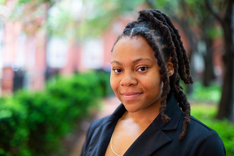 Rashema Melson stands outside with trees in the background.