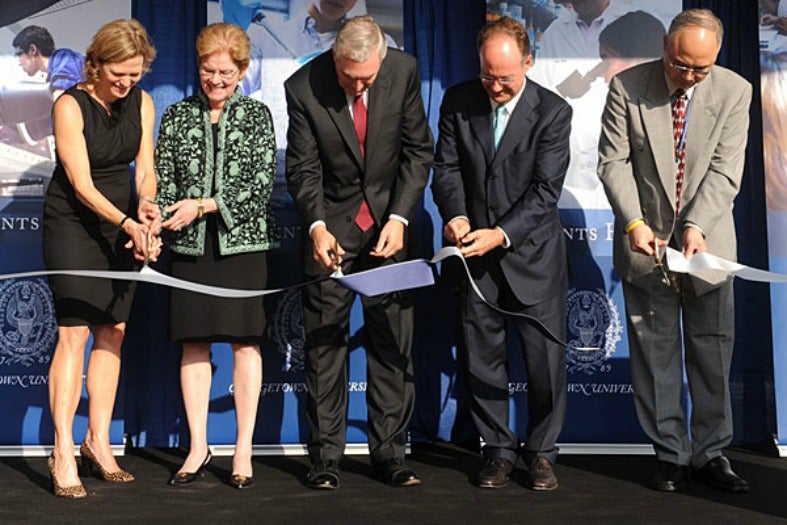 Jane Hopkins Carey, Jane Dammen McAuliffe, Chester Gillis, John DeGioia and YuYe Tong cut a ribbon 