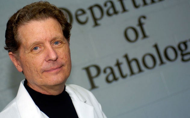 Richard Schlegel stands in front of sign for department of pathology that is partially cropped