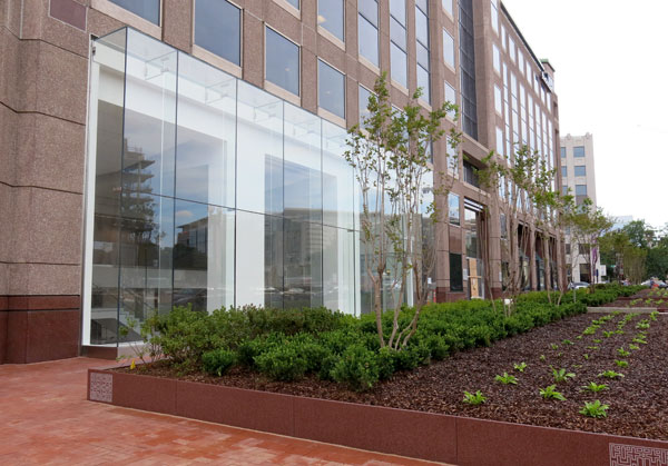 Exteriror of SCS campus on Massachusetts Ave NW shows glass entrance and landscaped trees and boxwoods