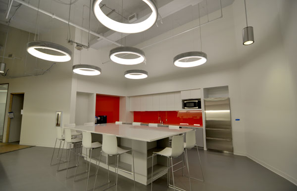 SCS meeting room with modern white furniture, modern lighting and a bold orange-red accent wall and door