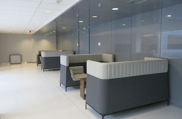 Two modern booths in gray upholstery line a hallway of student workspace at SCS