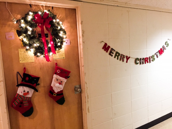 A wreath and banner outside of a dorm door.