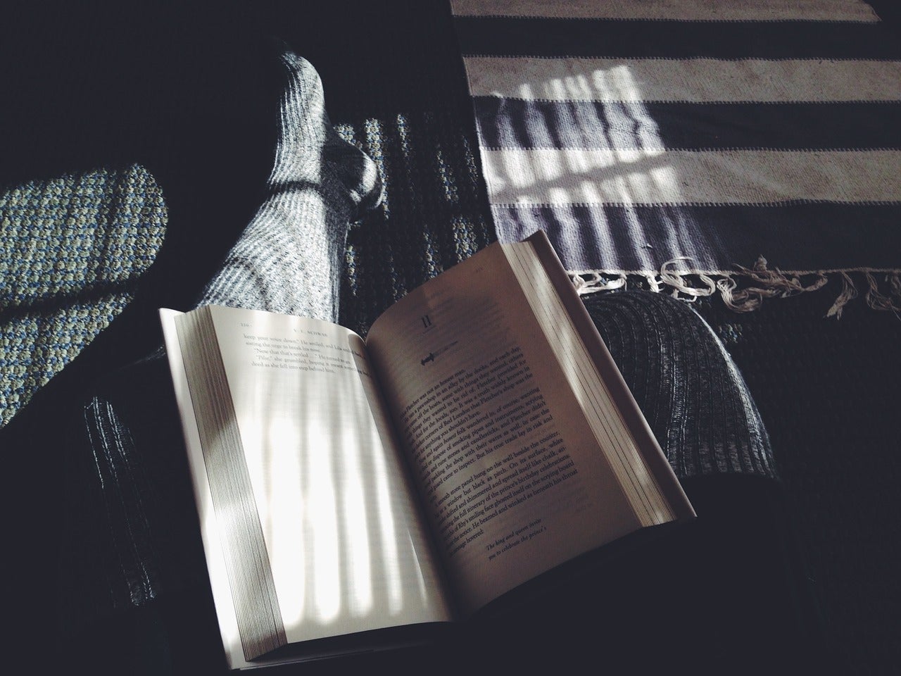 An open book rests on a students leg