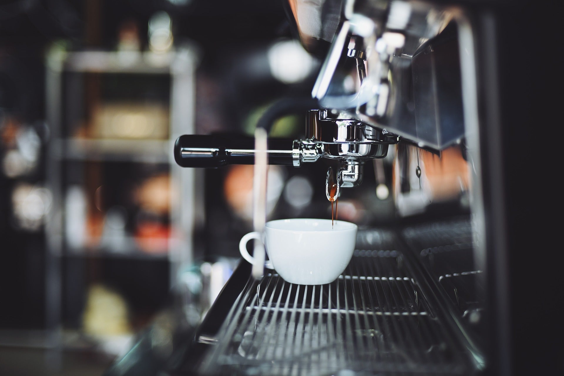 Espresso drips into a coffee mug in a cafe