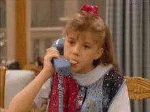 A moving gif of Stephanie Character from Full House popping a bubble of gum