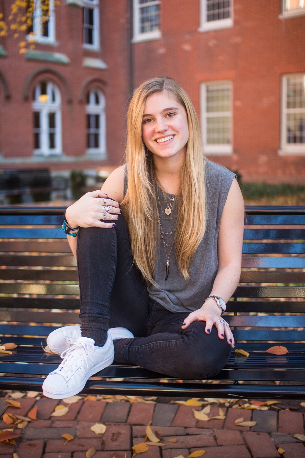 Anna Cardall smiles for the camera while sitting on a bench.