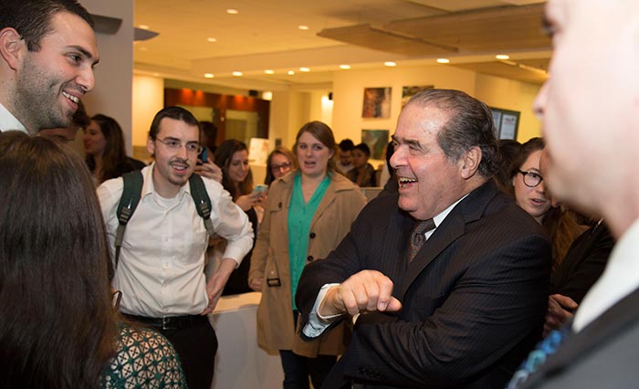 Antonin Scalia laughs while greeting students.