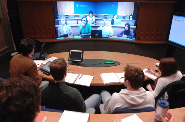 Students on Georgetown's Main Campus face a screen of students in Doha, Qatar in a classroom that allows for communication