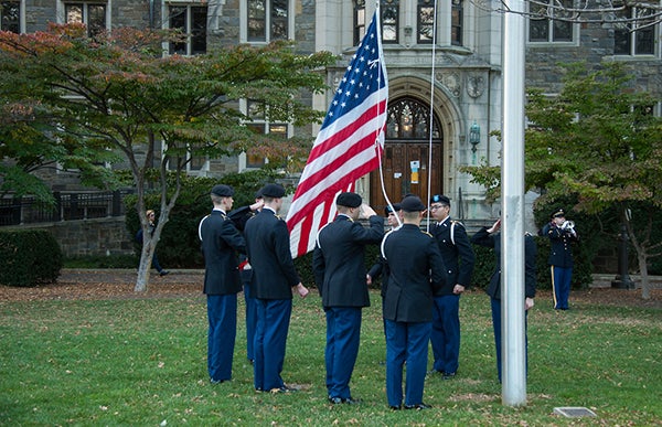 Members of the Hoya Battalion in uniform raise the American flag before closing the ceremony.