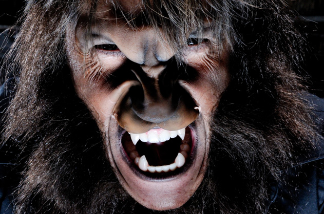 A closeup photo of a werewolf with bared teeth.