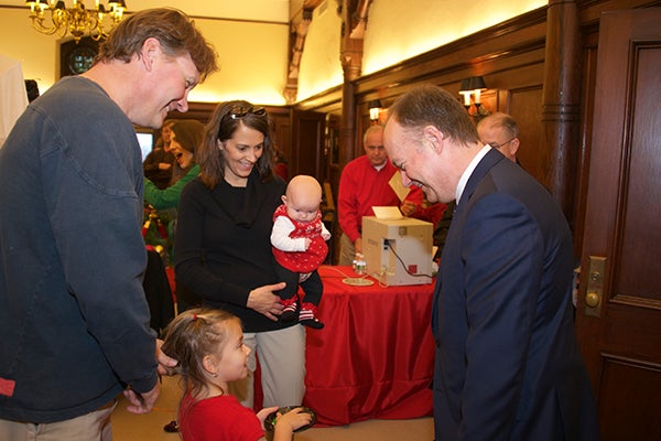 John J. DeGioia greets Pete Wilk with his daughter and his wife holding their other child