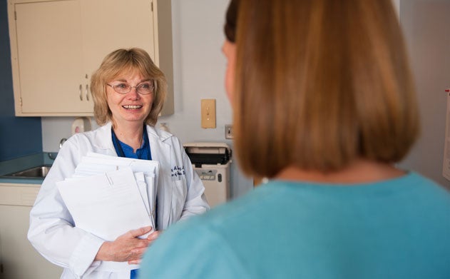 Mary Young looks at a woman in a doctor's office